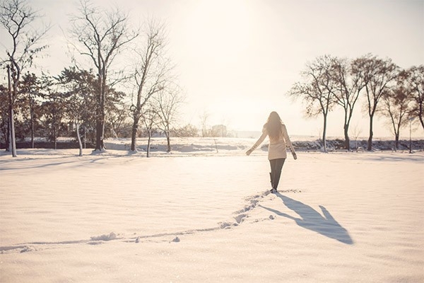 Frau spaziert im Schnee.